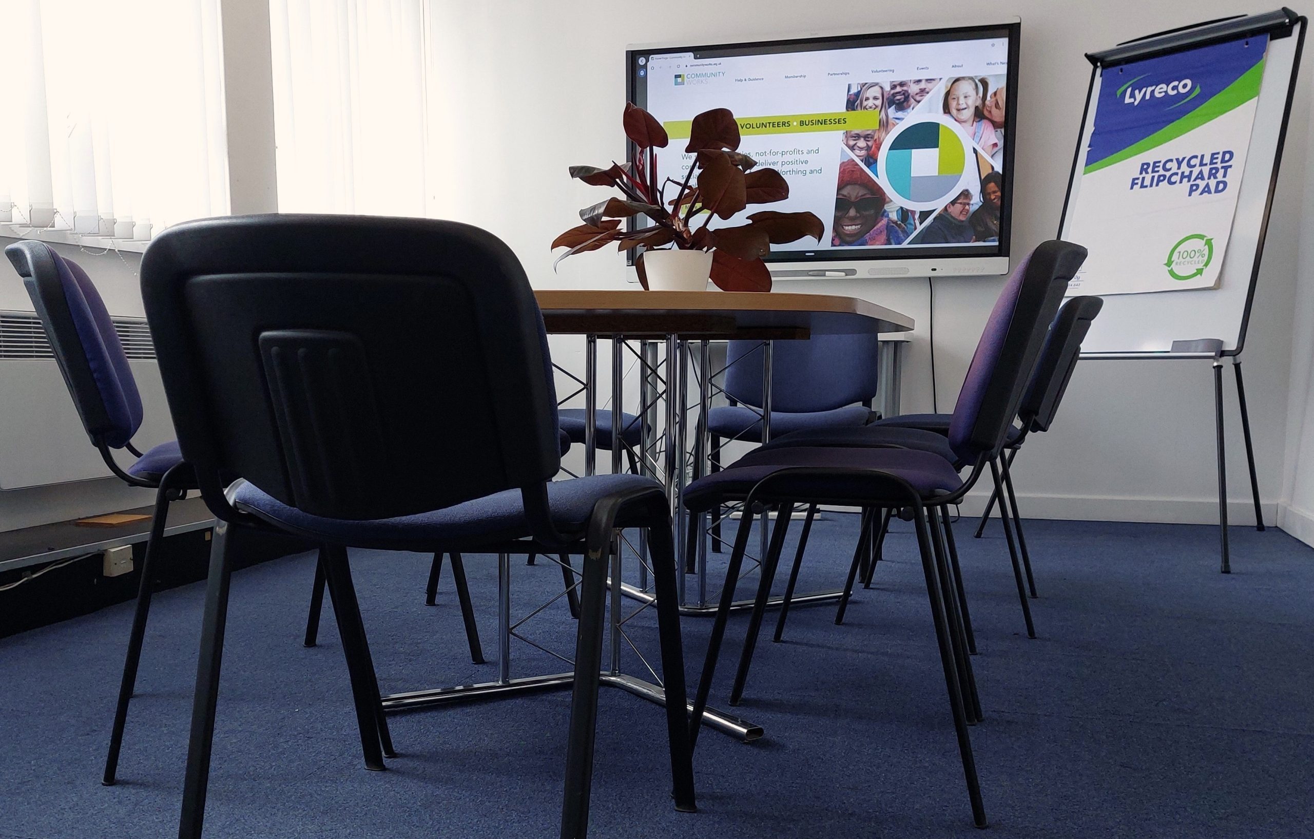 A large spacious meeting room featured in a large charity focused office on the third floor at Community Base.